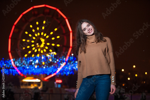 Young girl posing in a amusement park on a winter night.