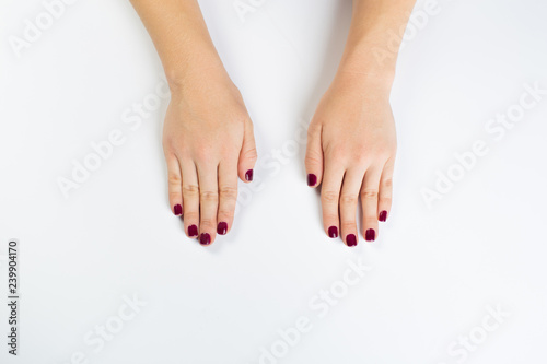 Top view photo of woman's hands with dark manicure