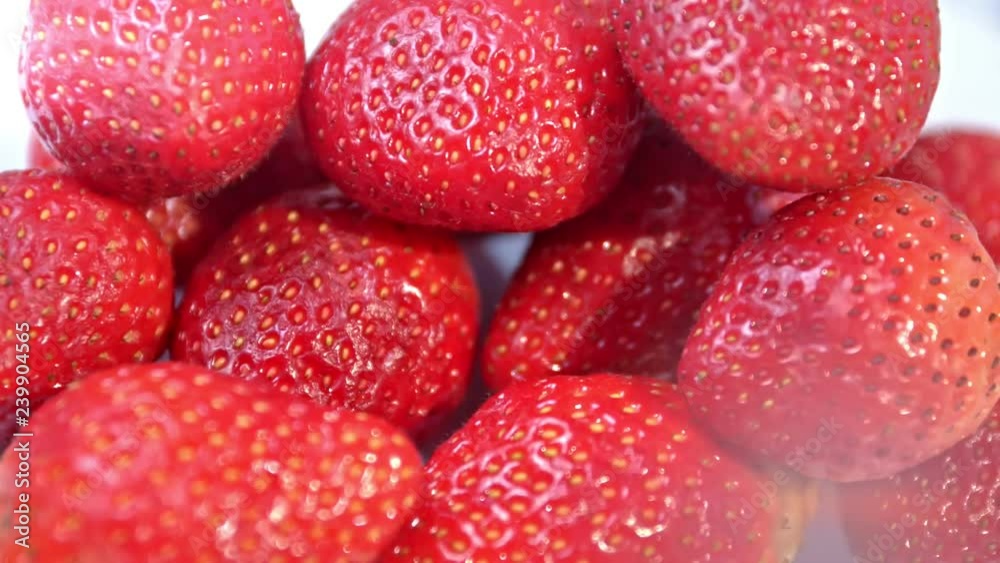 Close-up heap of glossy fresh and ripe red strawberries rotating shot Close-up heap of glossy fresh and ripe red strawberries rotating shot