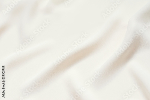 Matte cream delicate soft pleated fabric background. Smooth elegant luxury cloth texture. Gentle pastel color wedding background