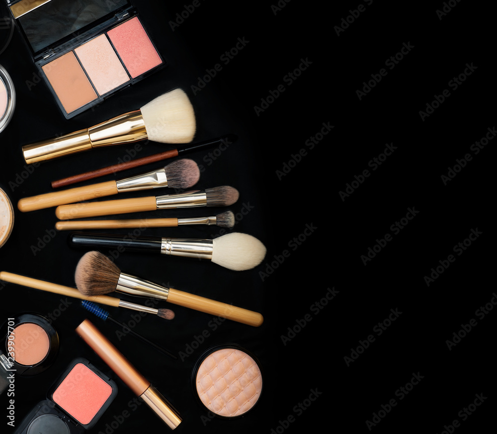 Set of make up brushes with cosmetics on black background Set of make up brushes with cosmetics on black background