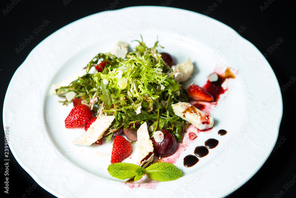 Strawberry tomato salad with feta cheese, olive oil on black background Strawberry tomato salad with feta cheese, olive oil on black background