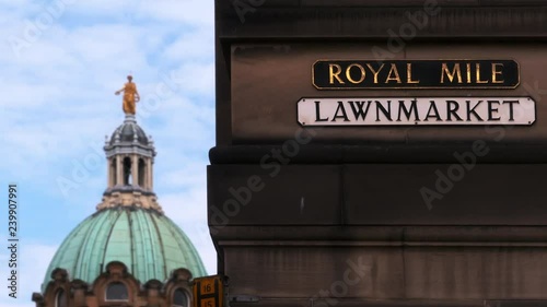 Royal Mile and Lawnmarket signs in Edinburgh, Scotland, with the dome of the Bank of Scotland defocused in the distance