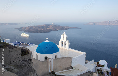 Whitewashed houses and blue dome church by the Aegean sea, Santoriniin Oia, Santorini, Greece. Famous blue domes in Oia village, Santorini, Greece - Immagine
