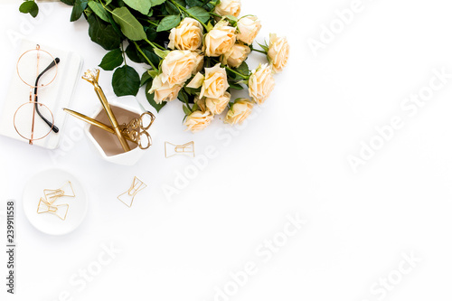 Female workspace with computer, roses flowers bouquet, golden accessories, diary, laptop, glasses on white background. Flat lay women's office desk. Top view feminine background.