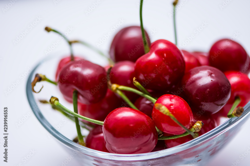 The glass bowl filled with ripe cherries The glass bowl filled with ripe cherries