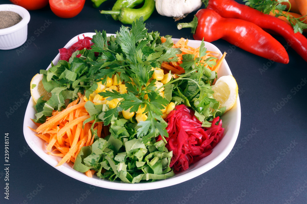 Green salad with fresh vegetables and green leaves at dark background. Green salad with fresh vegetables and green leaves at dark background.