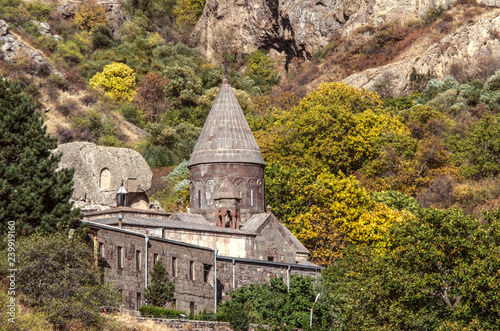 View of the whole complex of the cave monastery Geghard in the gorge of the Geghama ridge against the background of yellowed autumn trees in Armenia    