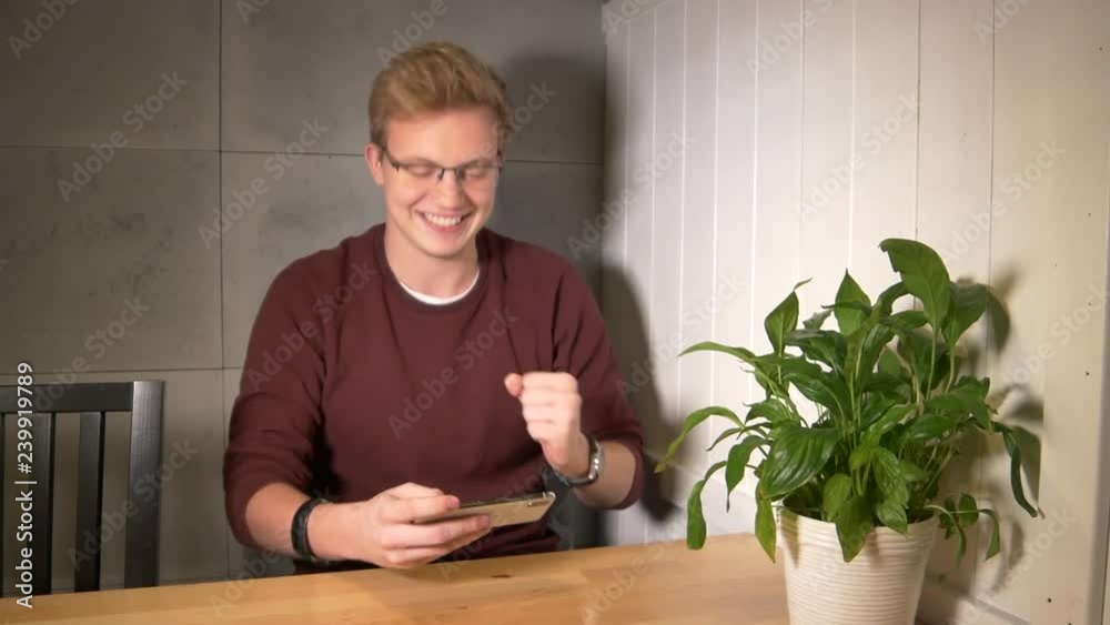 Man intensely playing the mobile game. Using smartphone horizontally. Winning the game Man intensely playing the mobile game. Using smartphone horizontally. Winning the game
