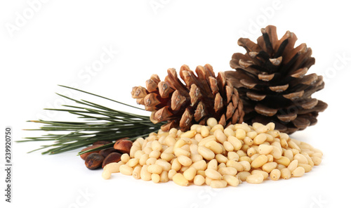 Heap of pine nuts and cones on white background