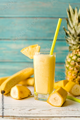 pineapple smoothie decorated with banana pieces and pineapples