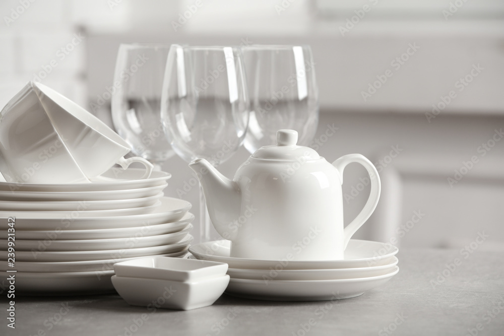 Set of clean dishes on table against blurred background Set of clean dishes on table against blurred background