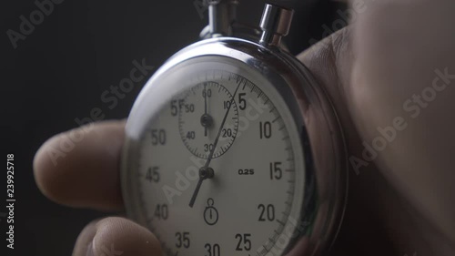 Close-up of one person starting up a stopwatch at grey background. 4K, 10 BIT, 4:2:2.