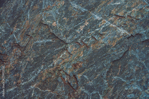 Plane of multicolored boulder in macro. Beautiful rock surface close up. Colorful textured stone. Amazing detailed background of highlands boulder with mosses and lichens. Natural texture of mountain.