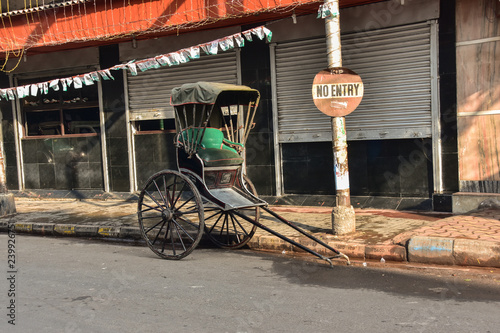 インドのコルカタの古い街並み　路上に停車する人力車　道路の標識と閉店中の店舗