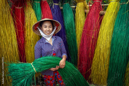 Portrait of Vietnamese female craftsman drying traditional vietnam mats in the old traditional village at dinh yen, dong thap, vietnam, tradition artist concept photo