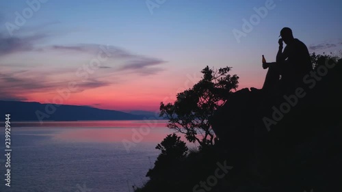 Sunset in Croatia. A man drinking beer and enjoying the view.