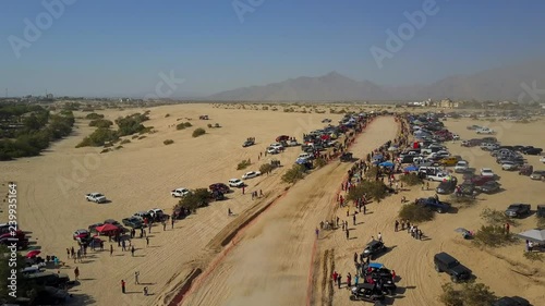 Aerial shot of the San Felipe 250 race. Trophy Truck comes from behind the camera and into frame driving with the camera movement. photo