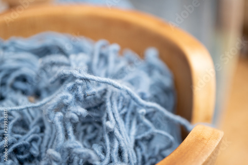 light blue natural dye thread in wooden bowl, selective focus