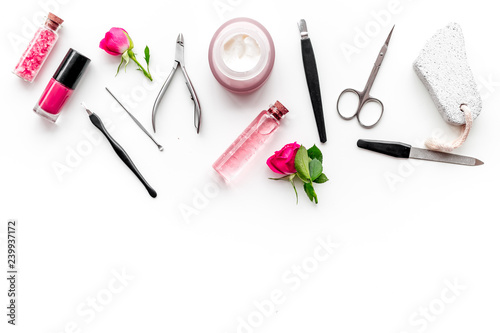 manicure equipment with nail polish and rose petals white background top view space for text