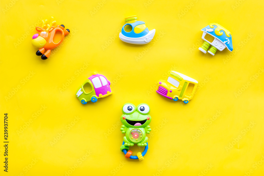 Obraz premium Craft toys for kids. Developing rattle for the smallest and baby bottle with milk. Yellow background top view mock up