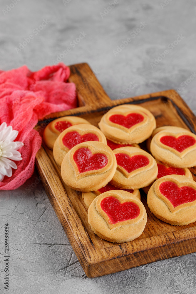 Cookies with a heart-shaped filling in on a wooden board. Concept for Valentine's Day.