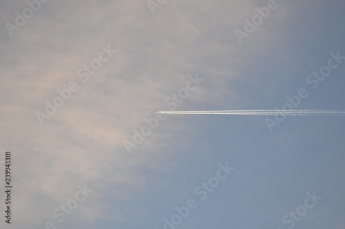 The plane flies in the evening sky