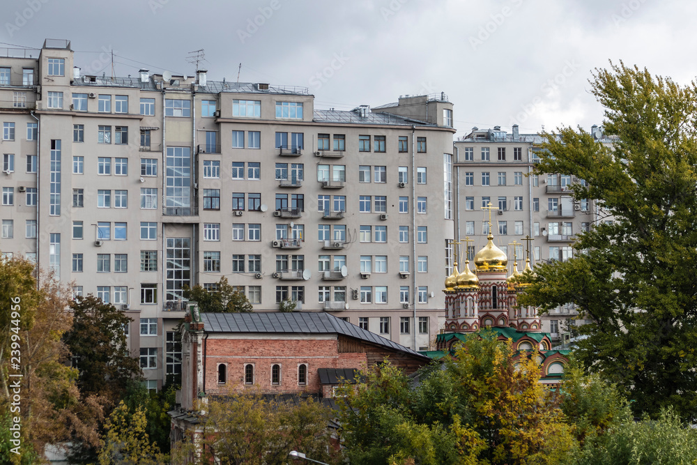 Massive residential building with orthodox church and park on a typical Moscow cityscape building Russia