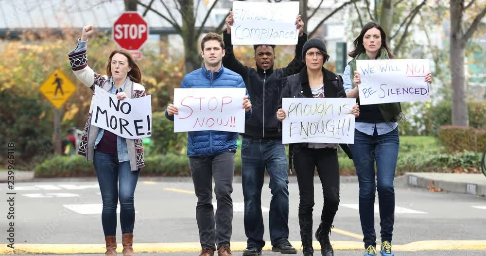 group of people protesting and chanting with signs