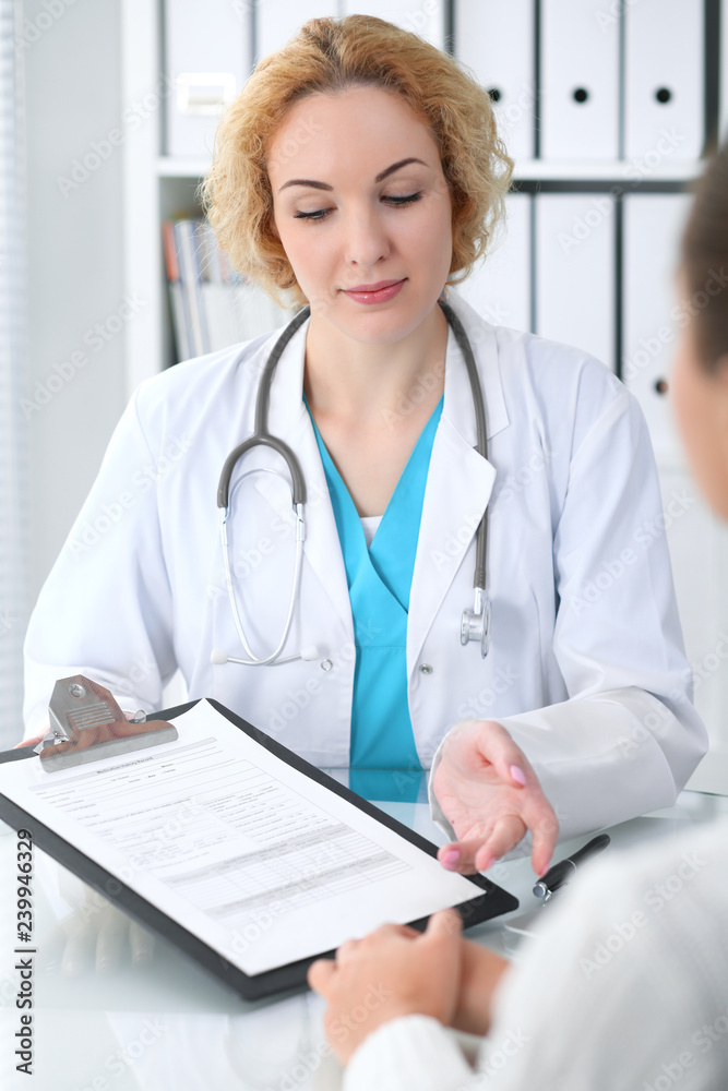 Happy blonde female doctor and patient discussing medical examination results. Medicine, healthcare and help concept Happy blonde female doctor and patient discussing medical examination results. Medicine, healthcare and help concept