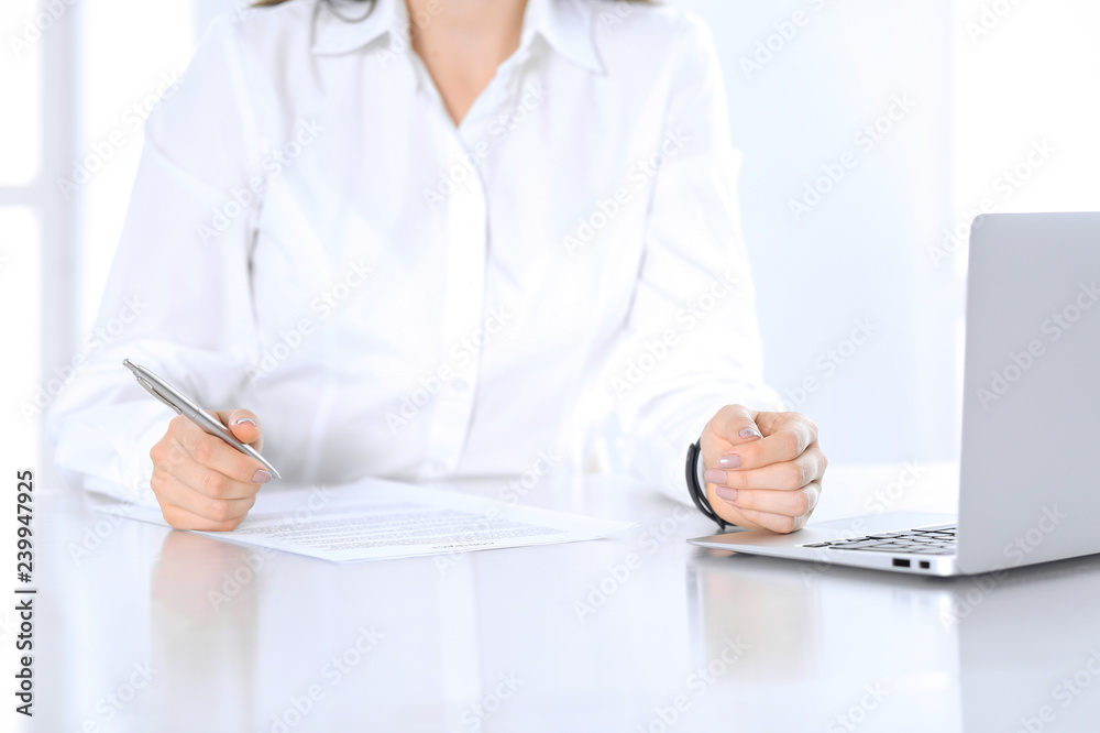 Close-up of female hands with pen over document, business concept. Lawyer or business woman at work in office Close-up of female hands with pen over document, business concept. Lawyer or business woman at work in office