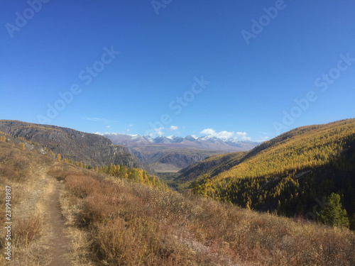 View of Altai mountains valley trail during autumn. Mountains ridge and clear blue sky