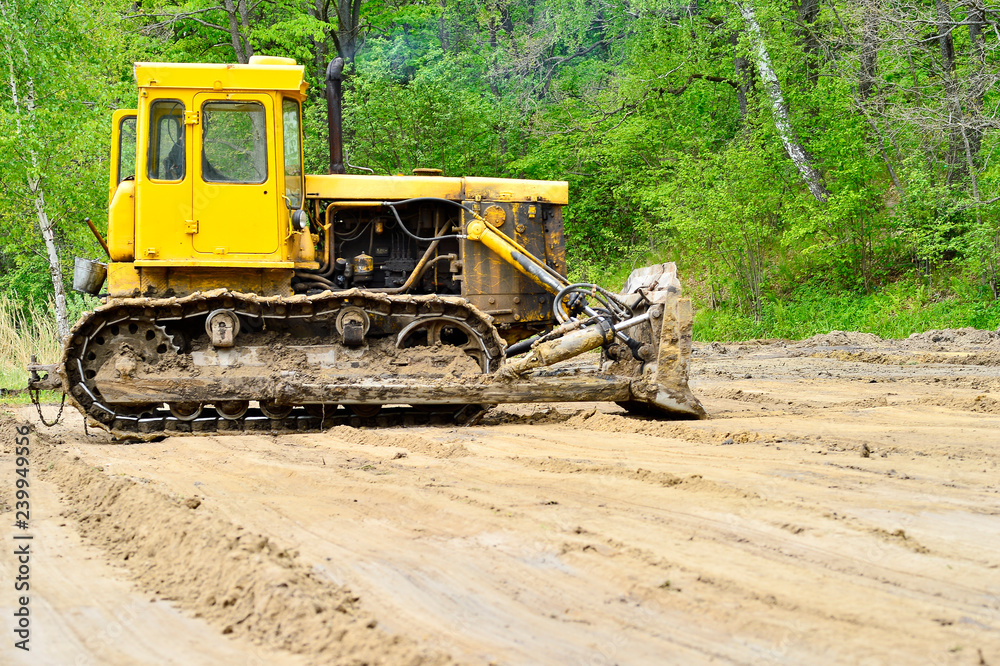 Tractor on tracks with a bucket on clearing the shoreline for the construction of beach volleyball courts. Tractor on tracks with a bucket on clearing the shoreline for the construction of beach volleyball courts.