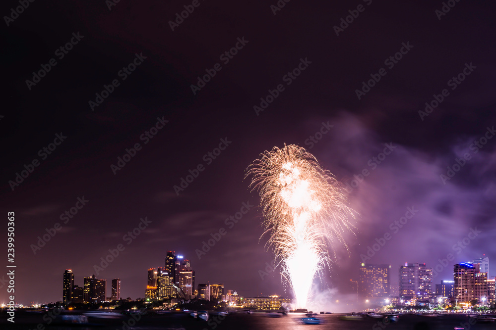 Beautiful fireworks shine on the sea with view of skyscrapers, Night sky with colorful fireworks above seascape, Pattaya, Thailand, Background for new year celebration with colorful fireworks 2019