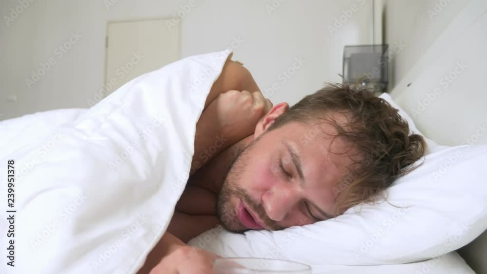 sick young man with fever asleep in bed, covered by a blanket sick young man with fever asleep in bed, covered by a blanket