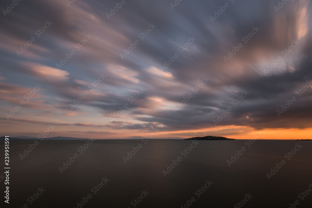 Beautiful wide angle, long exposure view of a lake at sunset, with an huge sky with moving clouds