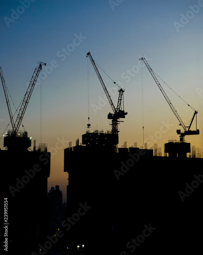 Silhouette of tower cranes at construction site