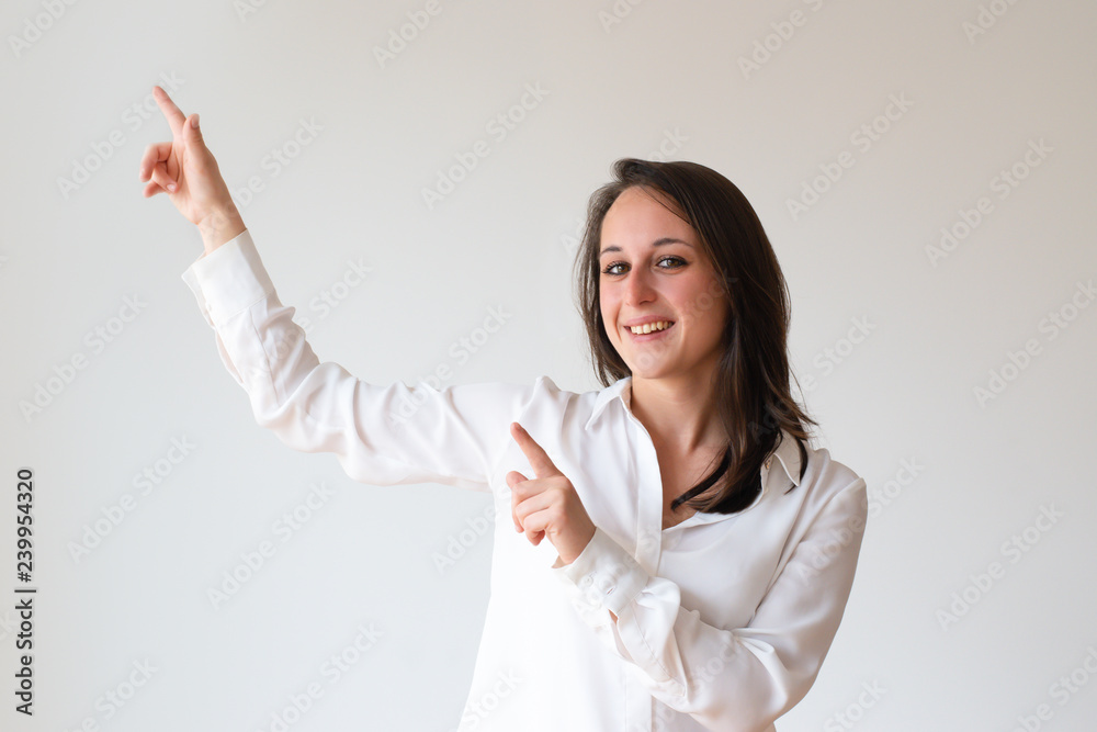 Cheerful content customer presenting new offer. Beautiful young woman pointing fingers at copy space upward. Advertising concept Cheerful content customer presenting new offer. Beautiful young woman pointing fingers at copy space upward. Advertising concept