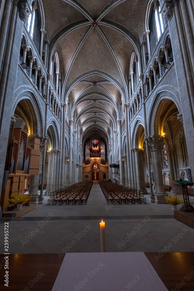 Interior of catholic cathedral, candle at foreground