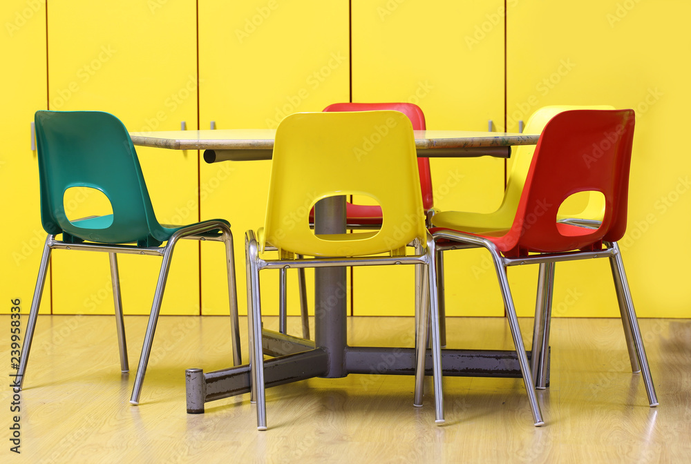 Fototapeta premium colored chairs around a table in a nursery school