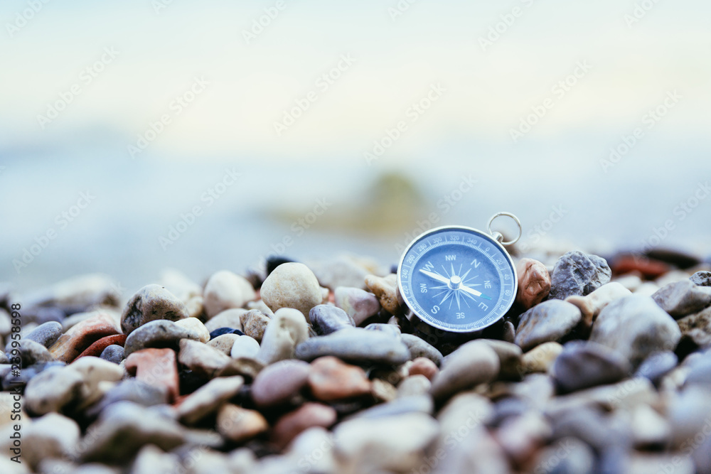 Compass on the beach, small stones, text space Compass on the beach, small stones, text space