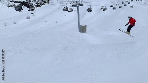 Skier skiing on mountain ski on springboard at snowy slope slow motion. Skier riding on ski and falling on mountain slope. Winter sport. Winter activities. Extreme sport concept photo