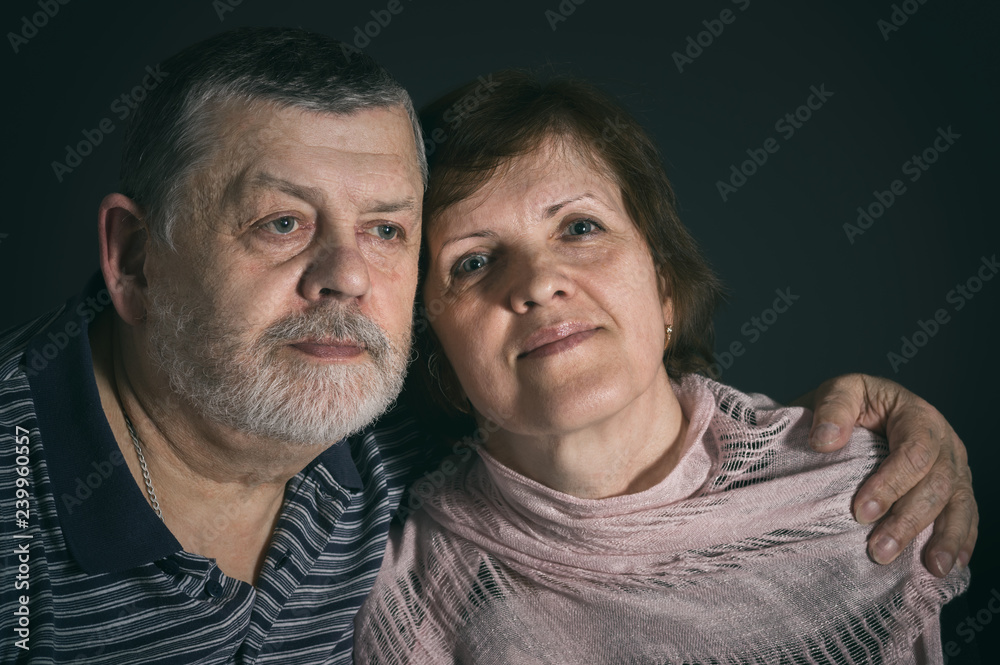 Indoor portrait of Caucasian senior man and woman in low key Indoor portrait of Caucasian senior man and woman in low key