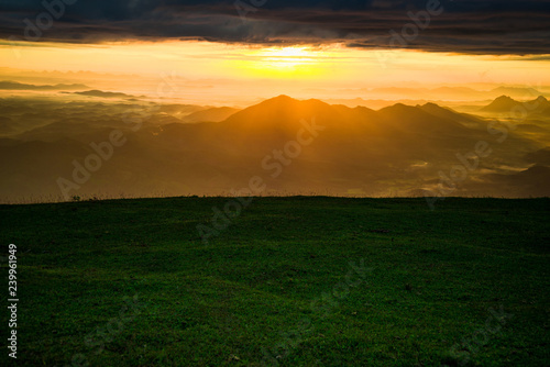 Sunrise landscape dramatic sky cloud sunrise on hill green grass on mountain Green field and beautiful sunset © Bigc Studio
