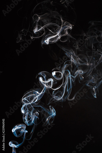 Actual incense smoke flowing up from a burning stick, isolated on black with tip of stick showing at extreme bottom of image.