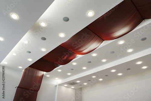 Modern layered ceiling with embedded lights and red cloth
