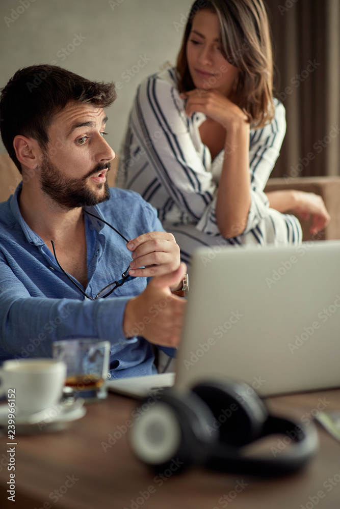 couple with laptop spending time together at home.