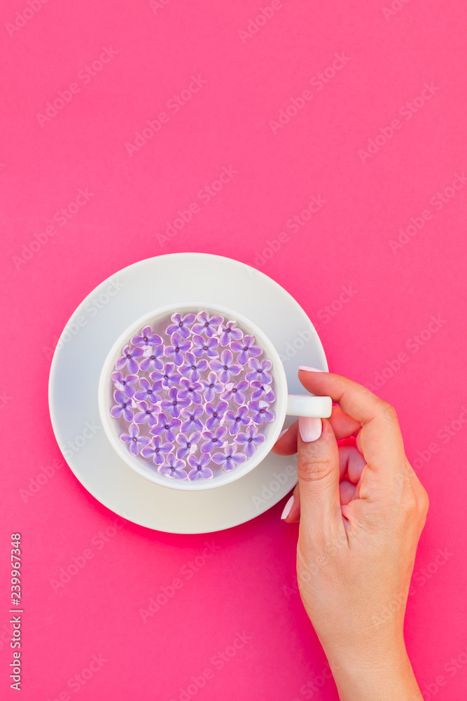Cup of beautiful lilac flowers infused water Cup of beautiful lilac flowers infused water