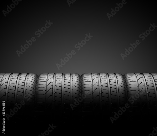 Car tires in row isolated on a dark background © Cla78