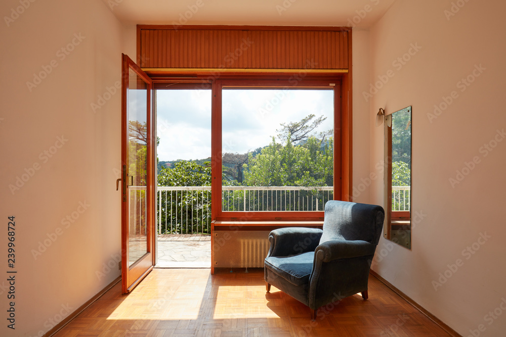 Fototapeta premium Sunny room interior with oen window and blue velvet armchair in country house